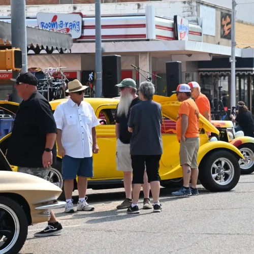 A group of adults gathered on Main Street for the annual car show