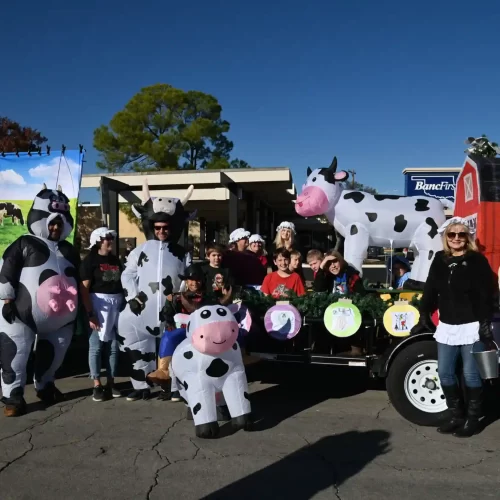 A trailer float featuring cow decorations and costumes for the Main Street Duncan Christmas parade